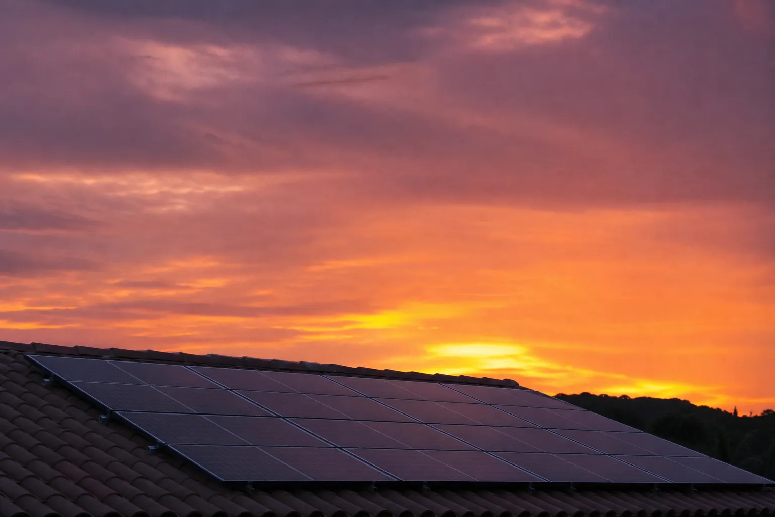 Panneaux solaires en toiture au crépuscule, ciel languedocien orangé et violet